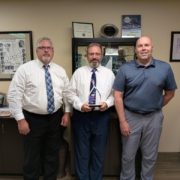 Three members of the Miner’s team holding the 2026 Truth in Cyber Cyber Champion Award