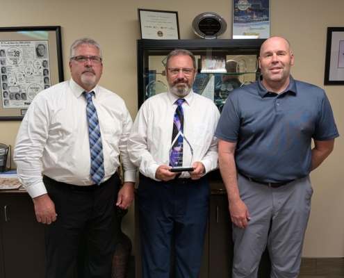 Three members of the Miner’s team holding the 2026 Truth in Cyber Cyber Champion Award