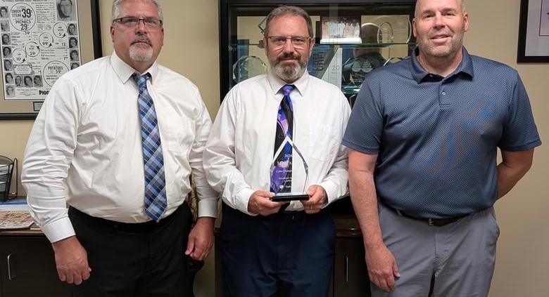 Three members of the Miner’s team holding the 2026 Truth in Cyber Cyber Champion Award